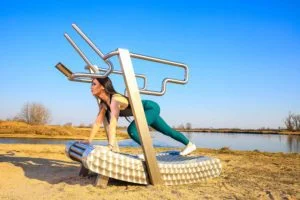 a woman exercises on the iGreenMill outdoor treadmill by the river